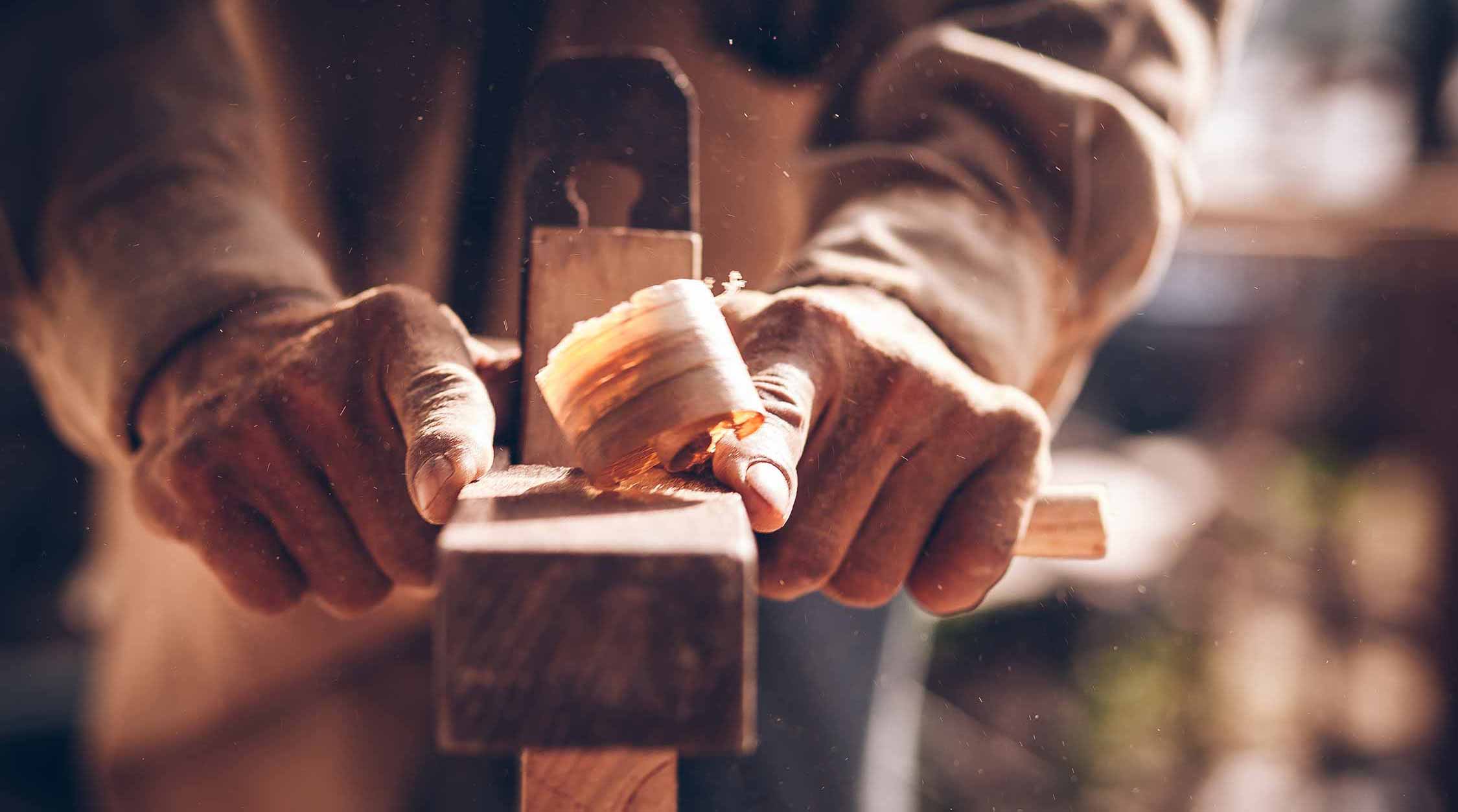 Carpenter planing on a planing bench